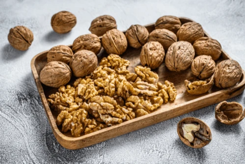 fruitri-walnut-kernels Walnut kernels arranged in a wooden tray